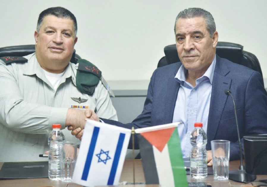 MAJ.-GEN. YOAV (POLY) MORDECHAI (left) shakes hands with Palestinian Authority Civil Affairs Minister Hussein al-Sheikh after agreeing to renew activities of the Joint Water Committee.