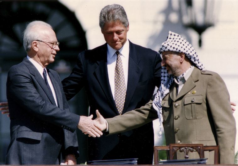 Then-PLO Chairman Yasser Arafat (R) shakes hands with then-prime minister Yitzhak Rabin (L), as U.S. President Bill Clinton stands between them Then-PLO Chairman Yasser Arafat (R) shakes hands with then-prime minister Yitzhak Rabin (L), as U.S. President Bill Clinton stands between them